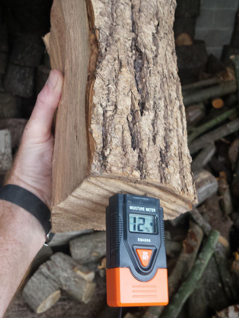 A moisture meter checking a split log